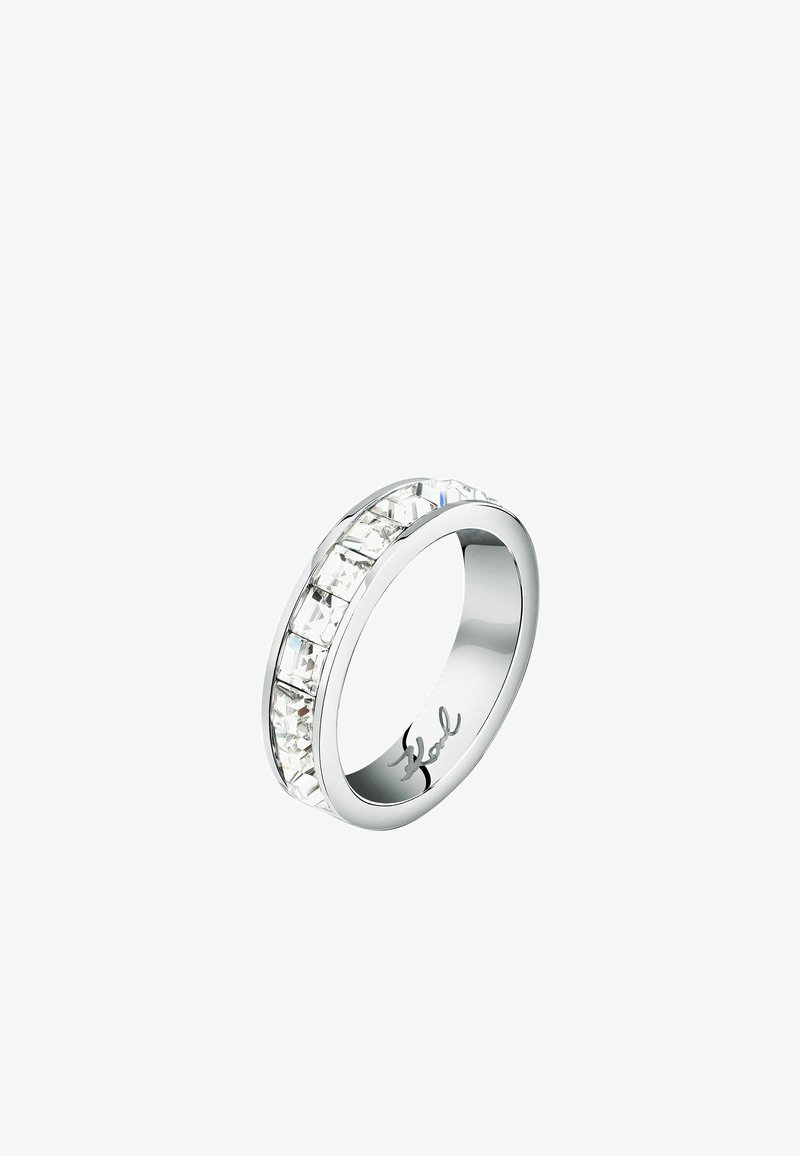 Zilveren ring met een rij rechthoekige heldere kristallen, een gepolijste, gladde band en subtiele merkbranding aan de binnenzijde.