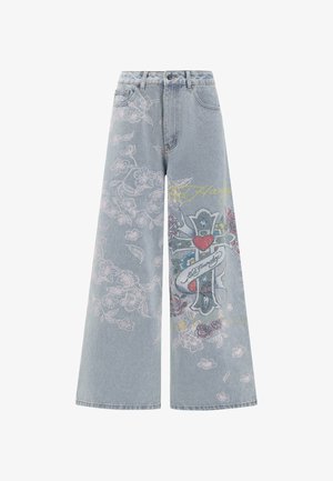 Vaaleansiniset leveälahkeiset farkut, joissa on kukkakirjontaa ja graafinen ristimuotoilu, värikkäillä yksityiskohdilla ja korkealla vyötäröllä.