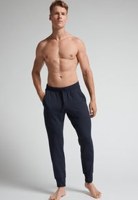 Marine joggerbroeken met een elastische tailleband en verstelbaar trekkoord, met taps toelopende benen en zacht, glad materiaal. Geen zichtbare patronen.