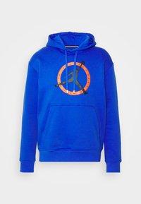 Sudadera azul con capucha, que presenta un logo en silueta negra y un diseño circular naranja. Está hecha de un material suave y tiene un bolsillo frontal.