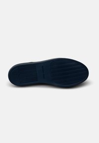 Suela de zapato de goma azul con superficie texturizada, que presenta surcos paralelos y un logotipo. Diseño plano con áreas elevadas para tracción.