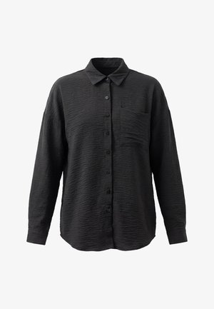 Musta, pitkähihainen nappipaita, jossa teksturoitu kangas, terävä kaulus, vasemman puolen rintatasku ja napilliset hihansuut.