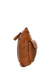 Sac à dos en cuir marron avec poche tissée à l'avant et fermeture éclair, présenté de profil sur fond blanc.