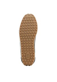 Zool van een sneaker met een gestructureerd, gumrubber oppervlak met ronde grips, omringd door een zwart-witte bovenrand.