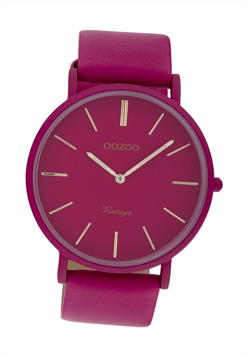 Montre ronde avec un bracelet en cuir fuchsia et un cadran fuchsia assorti. Index et aiguilles dorés. "Oozoo Vintage" imprimé sur le cadran.