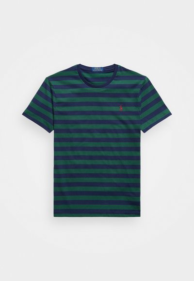 Πράσινο και ναυτικό μπλουζάκι με ρίγες φτιαγμένο από βαμβάκι, διαθέτοντας στρογγυλή λαιμόκοψη και μικρό κόκκινο λογότυπο στην αριστερή πλευρά του στήθους. Κοντά μανίκια.