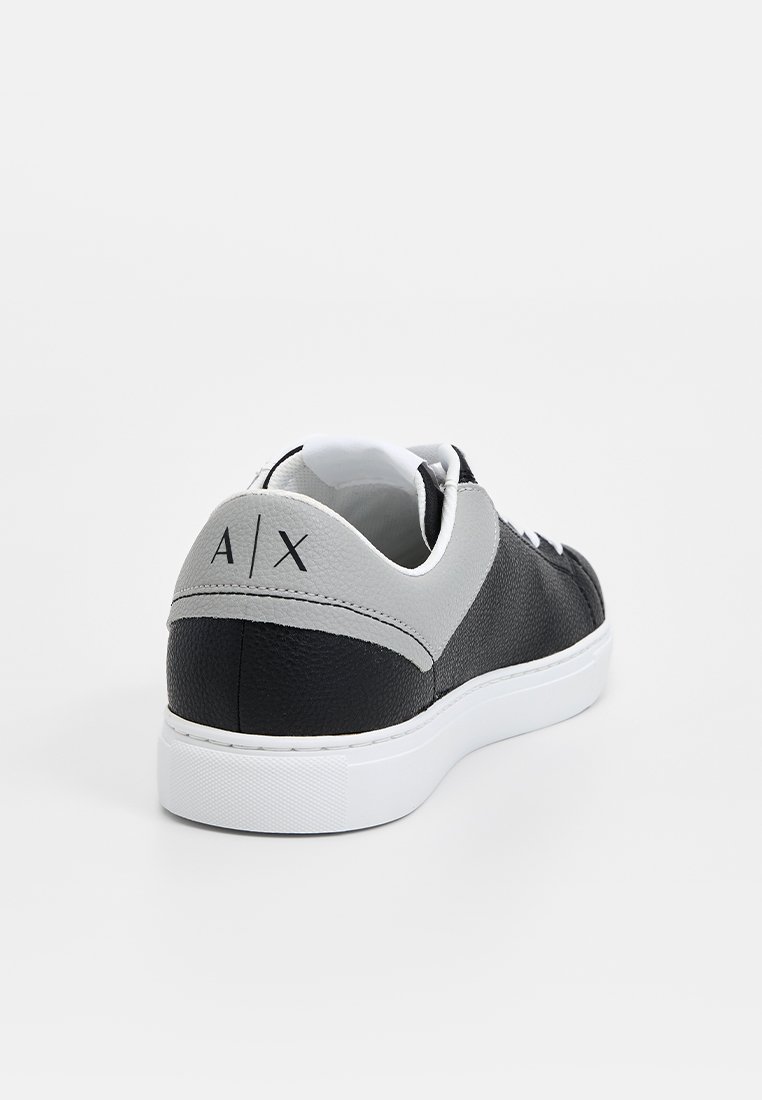 Czarny i szary sneakers z teksturowaną skórzaną cholewką, białą podeszwą i kontrastowymi akcentami. Posiada logo "A/X" na tyle.