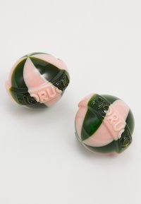 Fiorucci decorative spheres in green and pink plastic, featuring a glossy finish, striped design, and embossed logo detail.