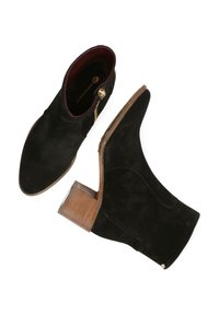 Botas negras de ante hasta el tobillo con suela de cuero, con un tacón bajo y un detalle de cremallera dorada a lo largo del costado.