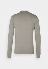 Lys grå langærmet strikket sweater med ribbet krave, manchetter og kant, vist fra ryggen på en ensfarvet hvid baggrund.
