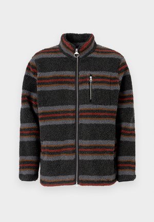 Jaqueta de polar preta com riscas horizontais vermelhas, castanhas e cinzentas, colarinho alto, fecho frontal com zíper e bolso no peito com zíper.