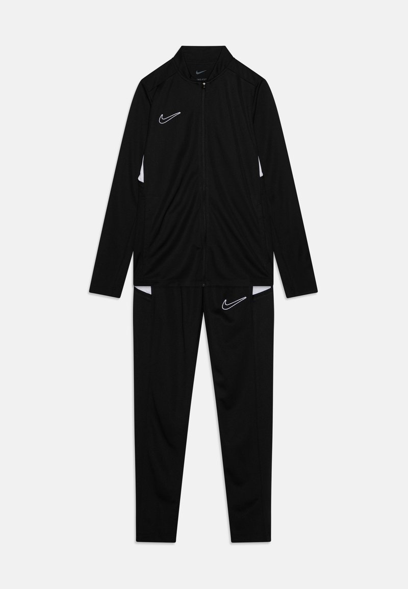 Αθλητική φόρμα της Nike με μαύρο μπουφάν με φερμουάρ και λευκές λεπτομέρειες, καθώς και μαύρο παντελόνι, και τα δύο κατασκευασμένα από ελαφρύ, απαλό ύφασμα.