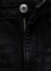 Černé džíny z denimu s kovovým knoflíkem a zipem, viditelnými švy a hladkou texturou.