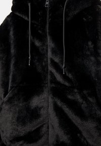 Črna umetna krzna jakna na zadrgo s kapuco, ki ima mehko teksturo, sprednje žepke in črne vrvice za prilagajanje.