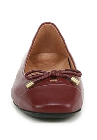 Ballerine in pelle bordeaux con punta affusolata, dettaglio a fiocco sul davanti e accenti in metallo color oro. Texture liscia, design minimal.