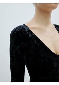 Schwarzes Samtkleid mit tiefem V-Ausschnitt, langen Ärmeln und einer glatten, weichen Textur mit subtilen Variationen im Stoff.