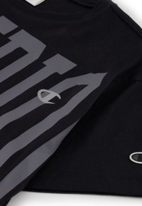Camiseta de algodón negra con un gran diseño gráfico y logotipo en color gris. Mangas cortas y cuello redondo con una textura suave.