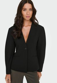 Černý blazer s hlubokým výstřihem do V, jednobušením a strukturovanými rameny. Má dvě přední kapsy a přizpůsobený střih.