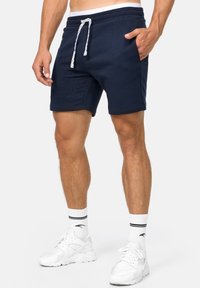 Navyblaue Baumwollshorts mit elastischem Bund, Kordelzug und seitlichen Taschen. Sie bieten eine glatte Textur und einen bequemen Sitz.