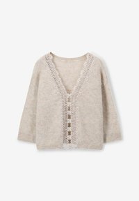 Pull en beige en laine, avec un décolleté en V profond et une garniture en dentelle sur le devant. Manches trois-quarts et coupe ample.