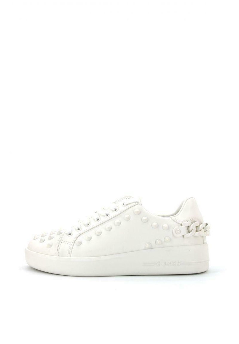 Zapatilla de cuero blanco con remaches redondos y piramidales, puntera redonda, parte superior con cordones y suela texturizada con un acento decorativo de cadena.