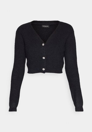Black cropped cardigan with long sleeves, ribbed texture, V-neckline, and four decorative buttons in the front. Made from a soft material.