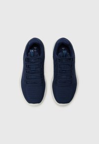 Navy athletic shoes with a textured knit upper, flat laces, and a white rubber sole. Reinforced toe and logo detail on the tongue.