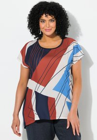 Top de manga corta y multicolor con un patrón geométrico en rojo, azul, blanco y azul marino, con un cuello redondo y un ajuste holgado.