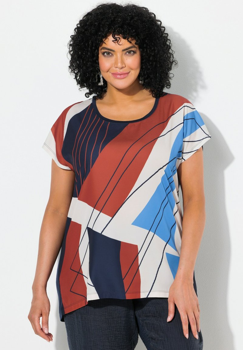Top de manga corta y multicolor con un patrón geométrico en rojo, azul, blanco y azul marino, con un cuello redondo y un ajuste holgado.