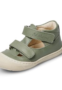 Zelené kožené sandály s suchým zipem, vyřezávaný design, texturovaná béžová gumová podrážka a prošité detaily. Logo značky viditelné na pásku.