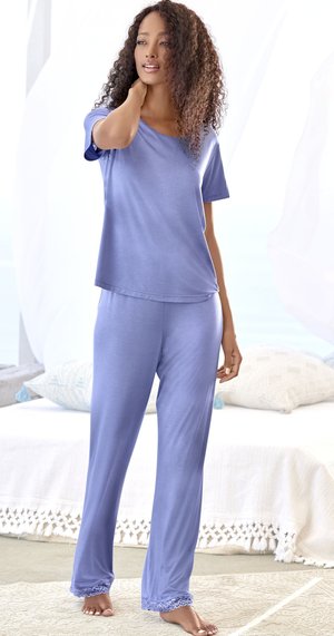 Lavendelfärgad pyjamasett gjord av mjukt tyg med en kortärmad topp och löst sittande byxor med spetsdetaljer vid ärmsluten.