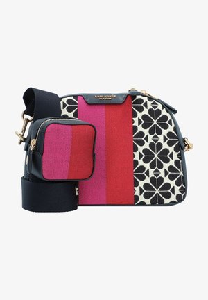 Sac bandoulière Kate Spade avec motif floral noir et blanc, large bandoulière noire, et petite pochette rayée rouge et rose attachée.