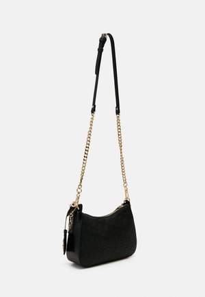 Black textured shoulder bag with gold chain and adjustable black leather strap, zipper closure, and attached round black tag.