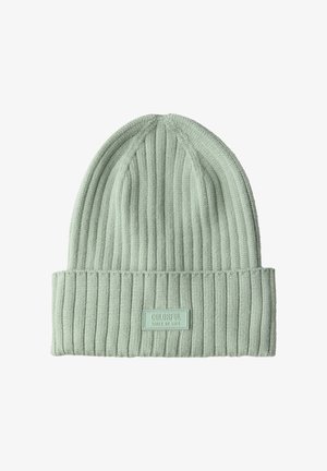 Gorro de punto verde claro con textura acanalada y un dobladillo. Cuenta con una etiqueta rectangular que dice "LADOS COLORIDOS DE LA VIDA."