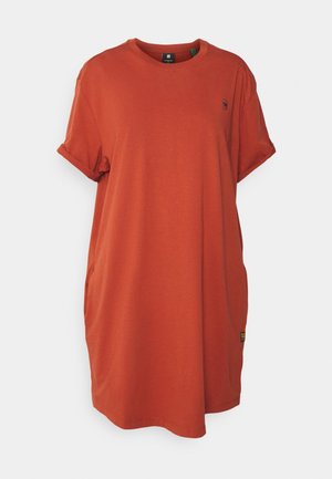 Robe t-shirt en coton orange avec manches courtes retroussées, encolure ronde et poches latérales. Présente un petit logo près de la poitrine.
