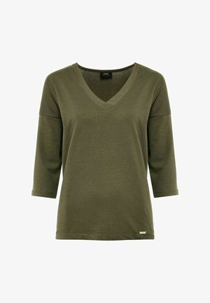 Oliwkowa bluzka z 3/4 rękawem i dekoltem w kształcie litery V wykonana z miękkiej, gładkiej tkaniny. Posiada kontrastowy dekolt oraz małą markową metkę u dołu.