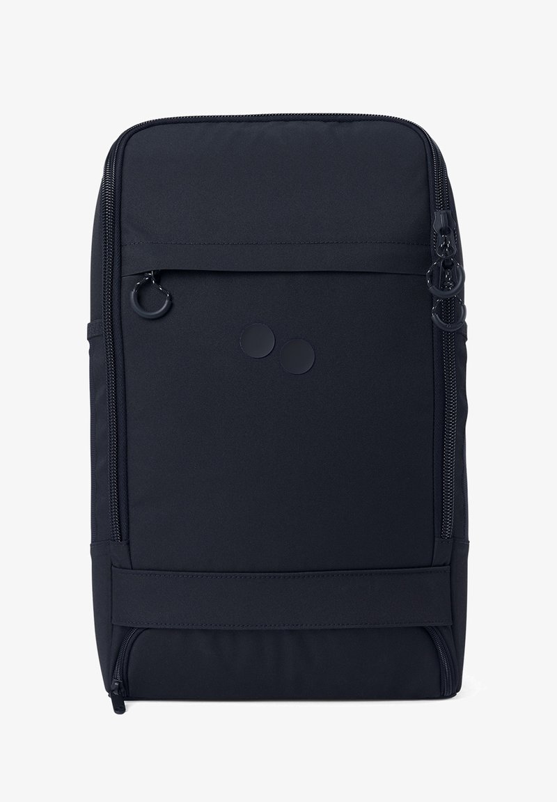 Schwarzer Rucksack aus strukturiertem Stoff, mit einer vorderen Reißverschlusstasche, zwei runden Akzenten und einem seitlichen Reißverschluss zur Erweiterung.