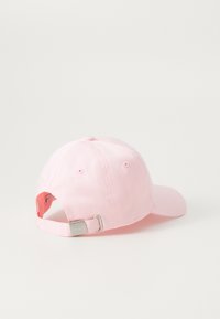 Rosa basebollkeps med en böjd skärm, justerbart band bak och textil med textur. Inga logotyper eller mönster synliga.