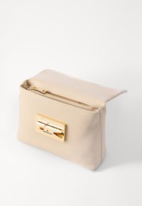 Beige syntetisk håndveske med glidelås, rektangulær form og en blank gullfarget aksent foran. Smyk overflate, minimalistisk design.