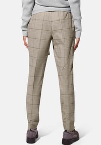 Beige geruite broeken met een op maat gemaakte pasvorm, met een gladde textuur en subtiele glans. Afgewerkt met een ritssluiting en zakken.
