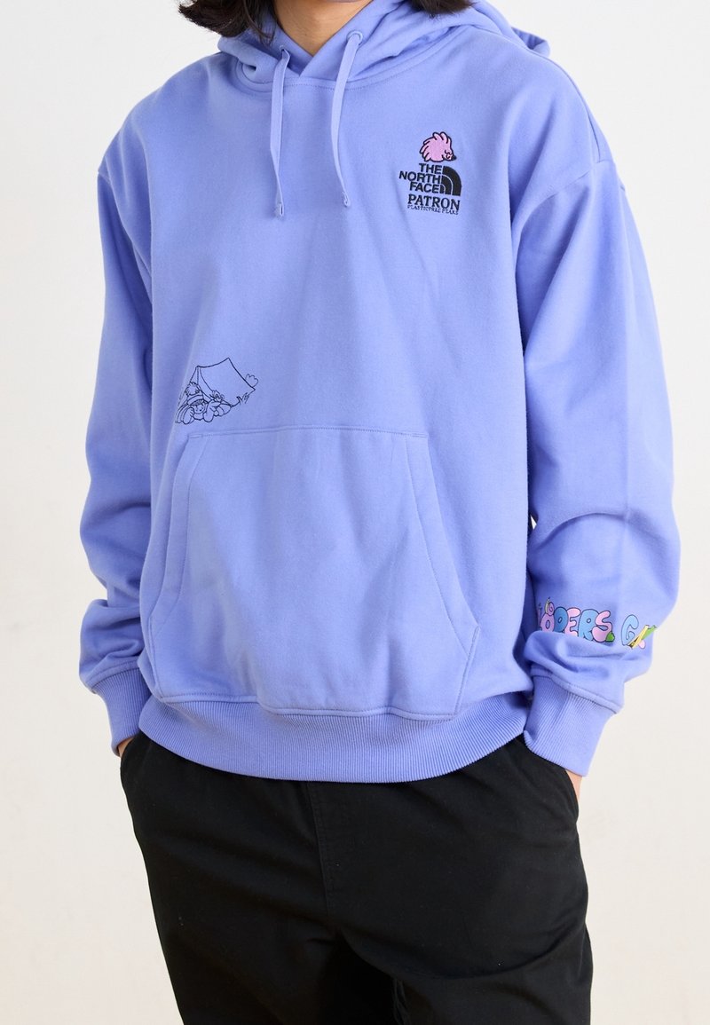 Ljuslila hoodie med framficka, dekorerad med broderade logotyper och ett blomsterdesign. Mudden har färgglada textaccents. Mjuk textur.