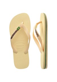 Tongs en caoutchouc marron avec un semelage texturé, des fines lanières et un détail du drapeau brésilien. Présente une bande multicolore le long du bord de la semelle.