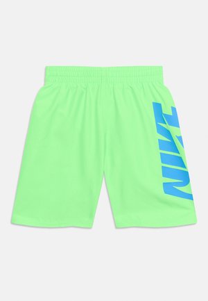 Ryškiai žaliai elastingi šortai su dideliu mėlynu „NIKE“ užrašu vertikalia kryptimi dešinėje kojoje.