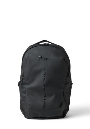 Mochila negra con asa superior, con el texto "Utopia" y "Design Studio Milan, Italy 2021" en el panel frontal.