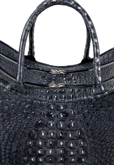 Sac à main en cuir noir à texture crocodile avec deux poignées et deux fermetures éclair argentées visibles sur le dessus.