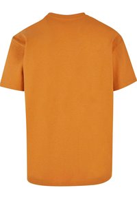 Kortærmet t-shirt i lys orange bomuld, med rund hals og et simpelt, udekoreret design på ryggen. Blød tekstur.