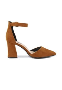 Scarpa con tacco alto in suede marrone, con punta affusolata, cinturino alla caviglia e tacco a blocco, caratterizzata da una texture liscia e suola nera.