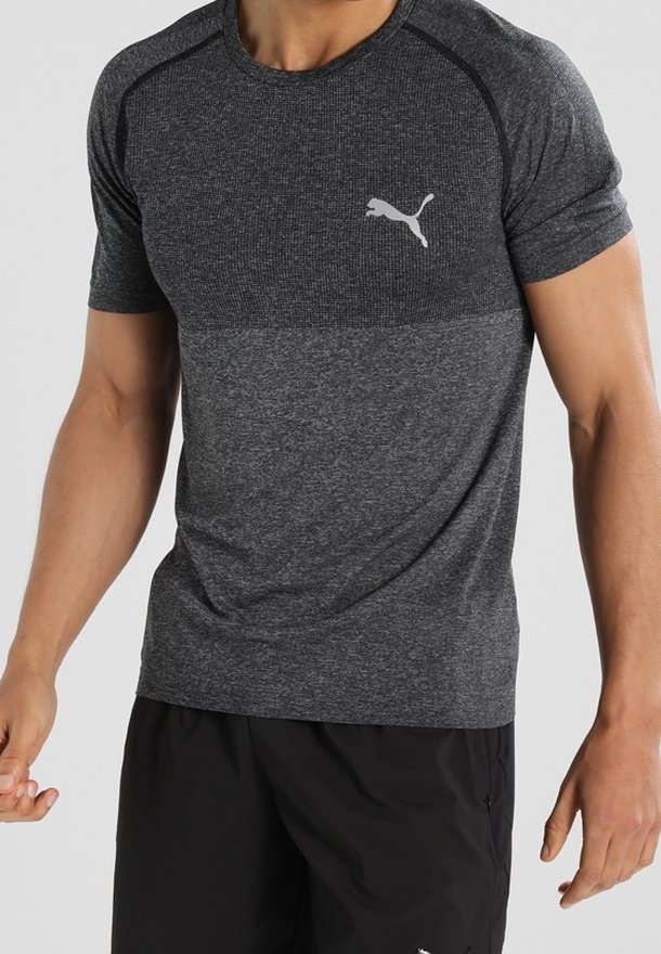 Šedé sportovní tričko s texturovanou vrchní částí, krátkými rukávy a bílým logem Puma na hrudi. Hladká látka, vypasovaný střih.