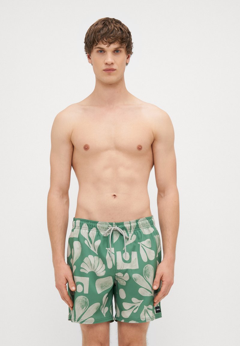 Πράσινα μαγιό με λευκό αφηρημένο σχέδιο φύλλου. Το υλικό είναι ελαφρύ με ελαστική μέση και κλείσιμο με κορδόνι.