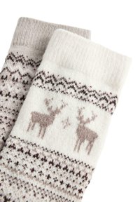 Para skarpetek z dzianiny wełnianej, jedna biała, druga beżowa, z brązowymi reniferami i tradycyjnymi wzorami fair isle.